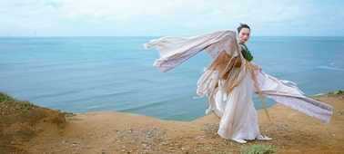 Imagen de ejemplo que muestra a una mujer con traje de época y la costa de fondo