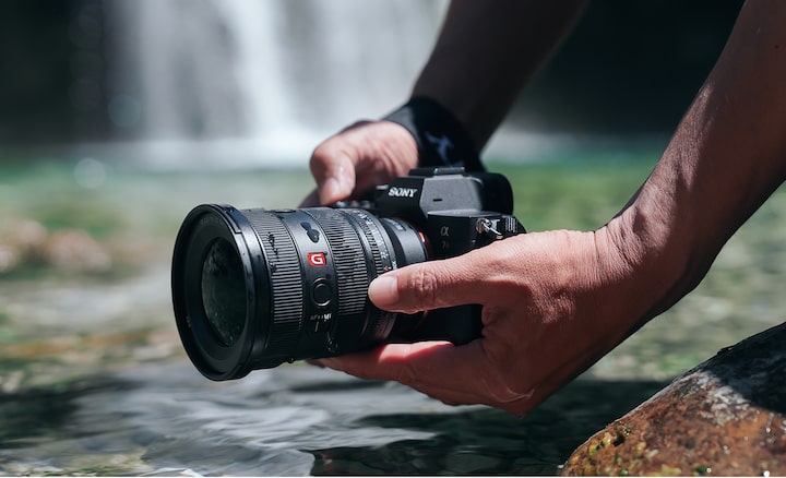 Acercamiento de una persona haciendo capturas junto al agua.